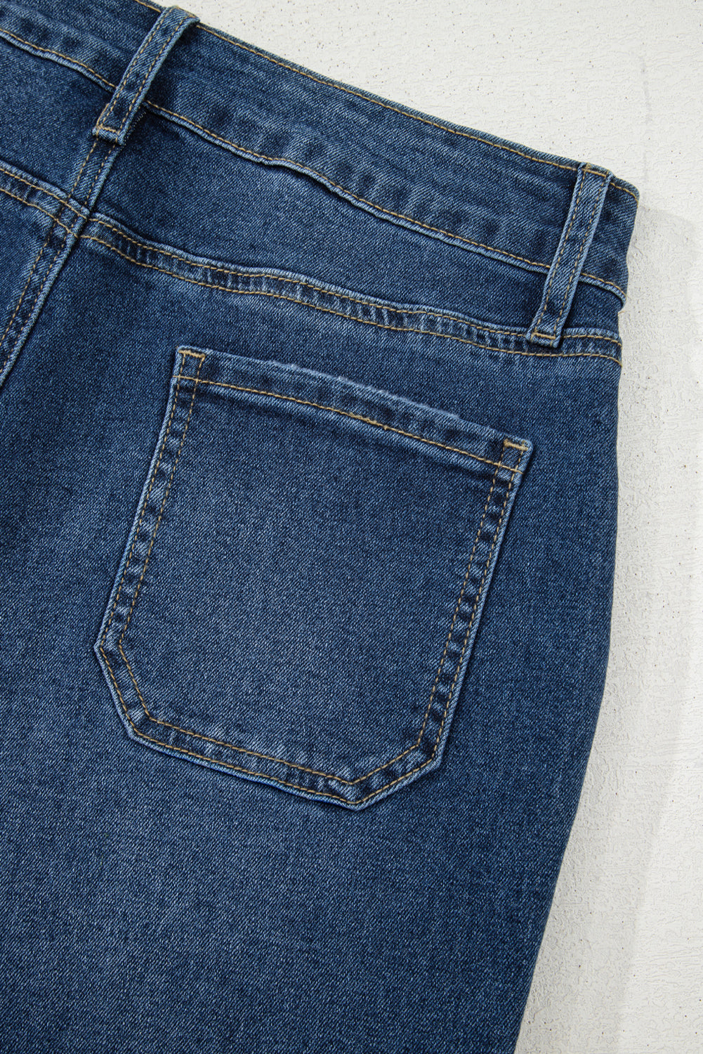 Close-up of blue denim jeans with a pocket on a light gray background