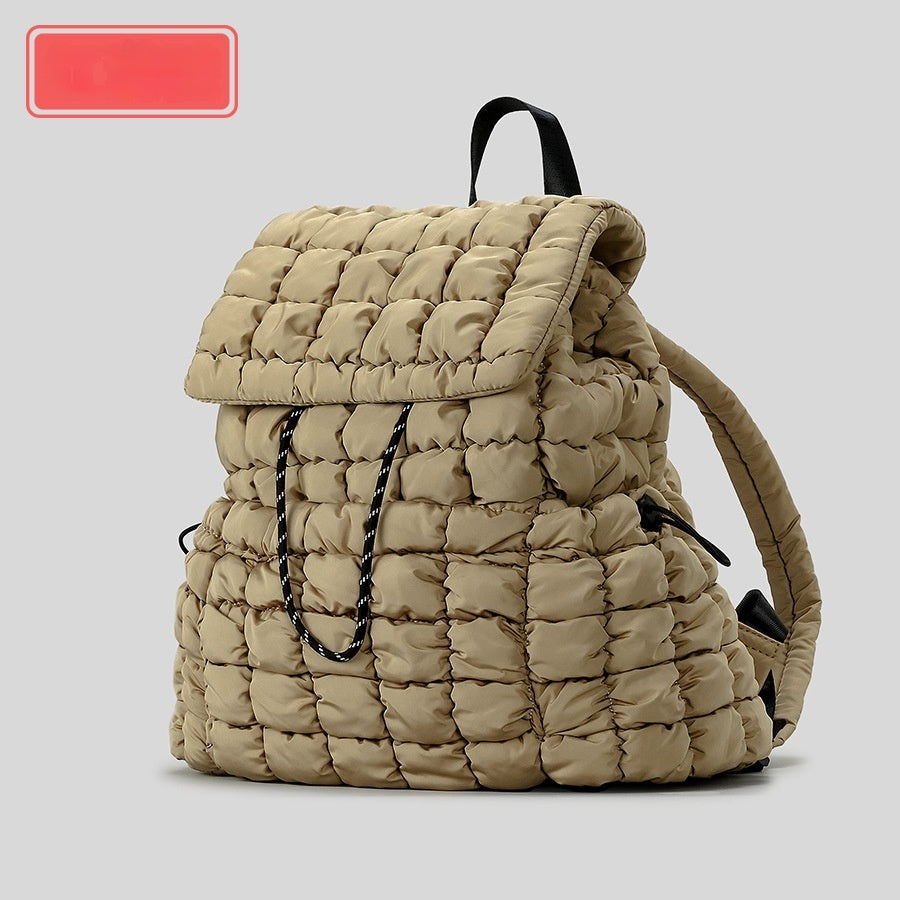 Beige quilted backpack on a light gray background