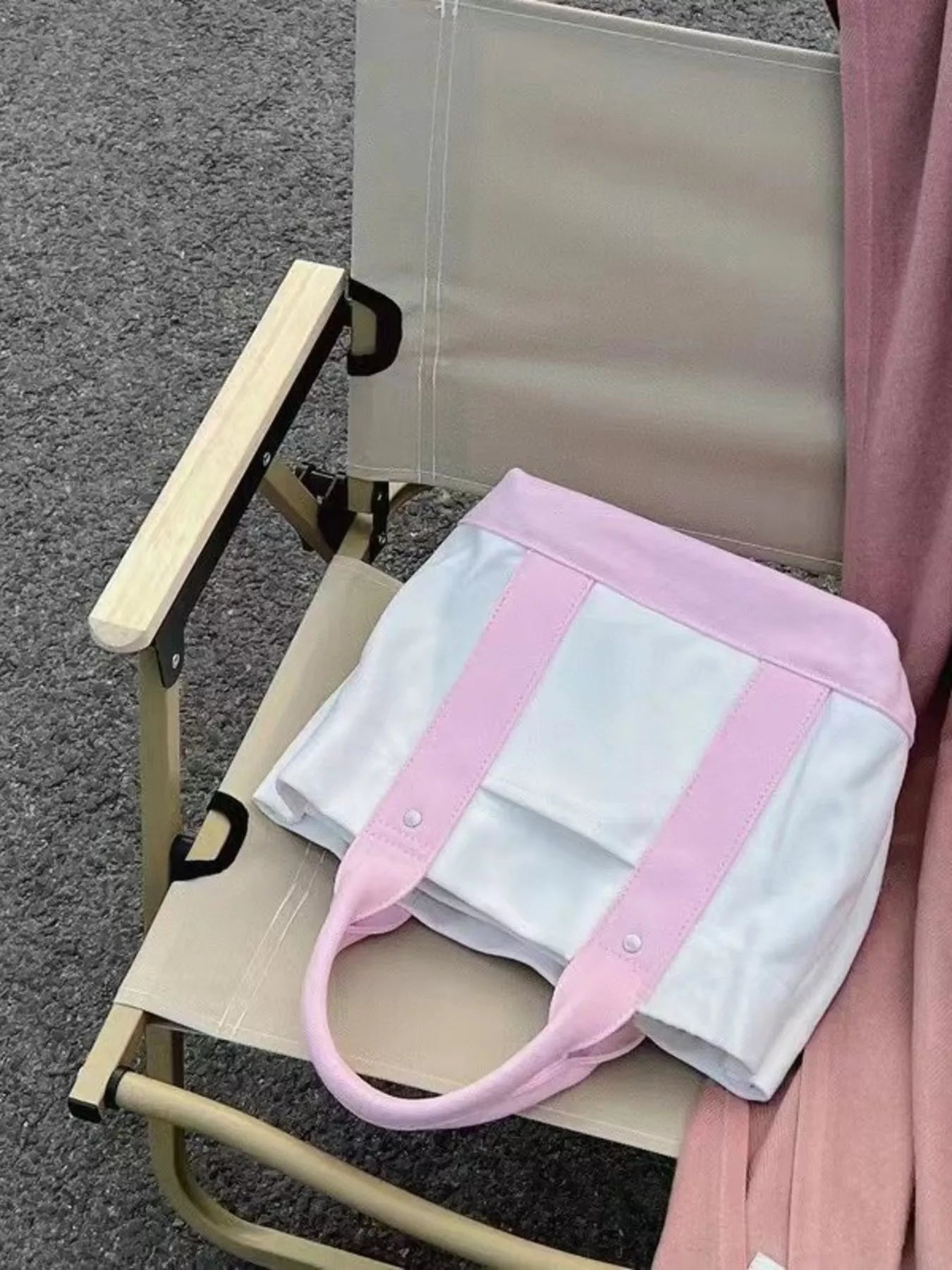 White bag with pink straps on a folding chair outdoors