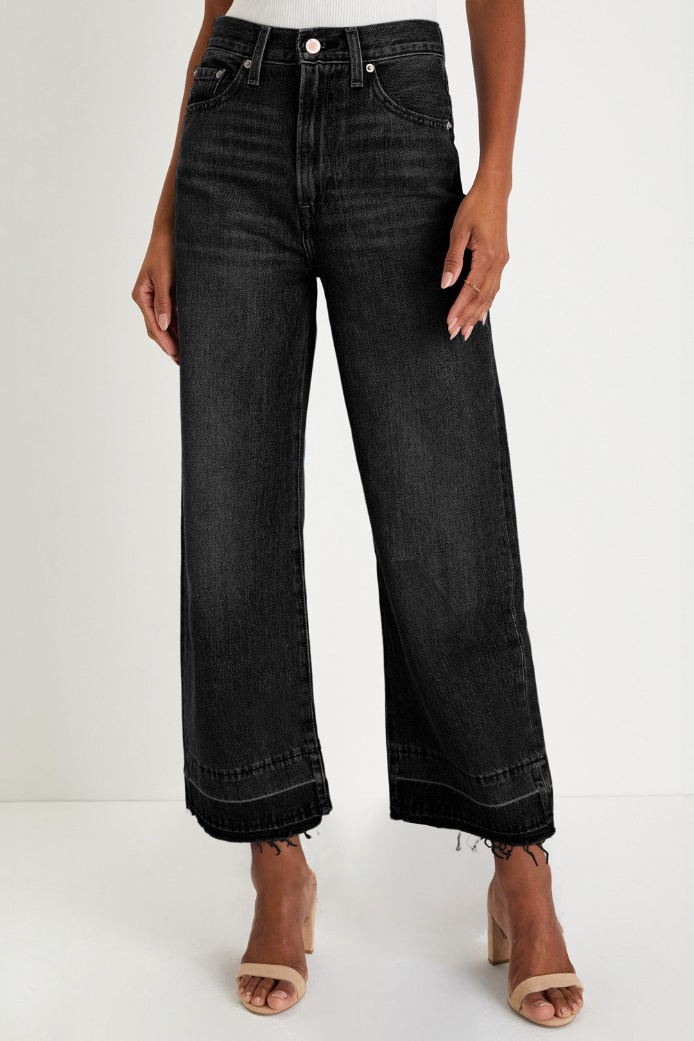 Black wide-leg jeans worn by a person on a white background