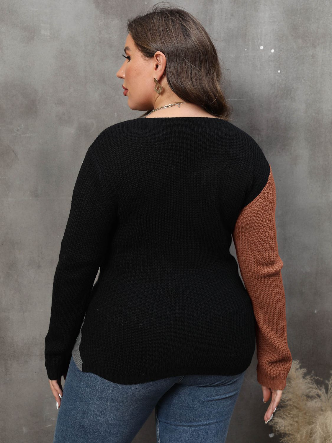Back view of a model wearing a black and caramel colorblock sweater.