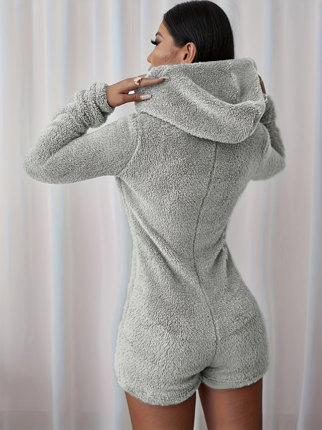 Back view of a Model wearing a Women's Cozy Furry Half Zip Long Sleeve Hooded Bodysuit