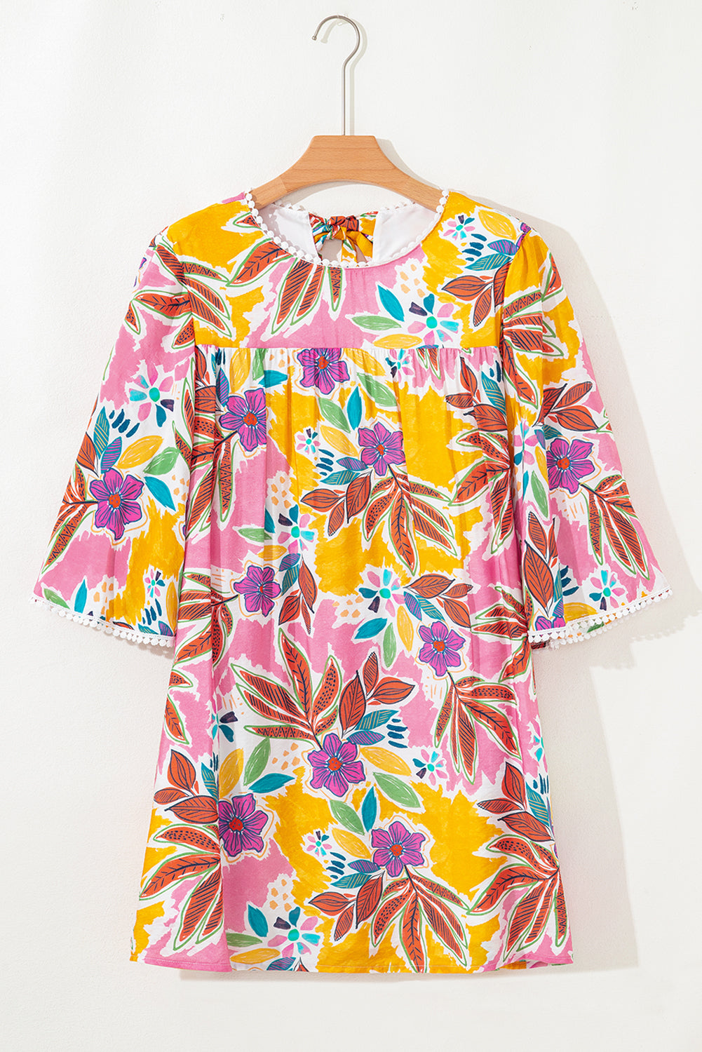 Front view of a vibrant floral dress with 3/4 sleeves, showcasing a mix of pink, yellow, and green flowers