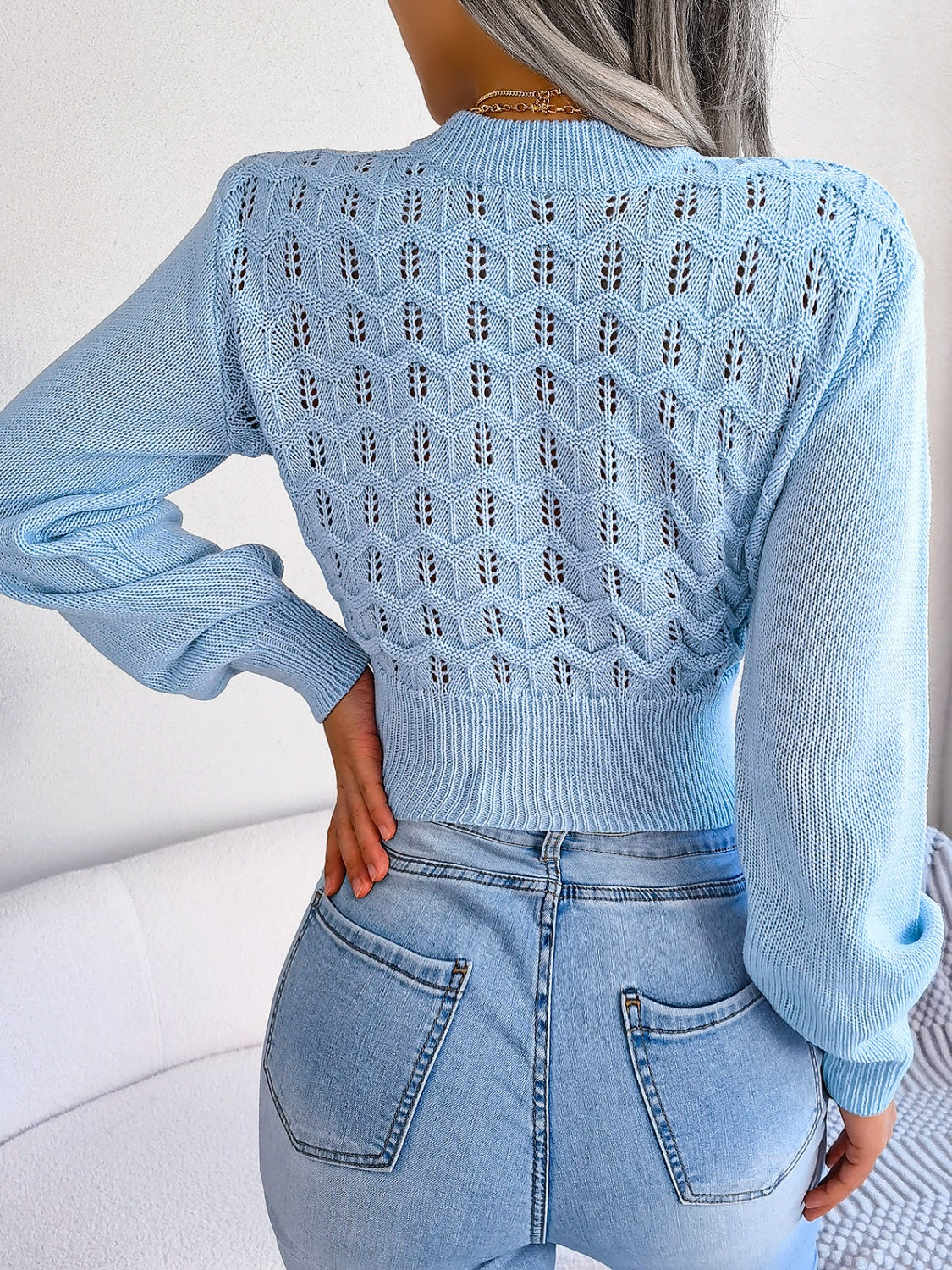 Back view of Women's Exquisitely Contemporary Openwork Mock Neck Cropped Pastel Blue Sweater
