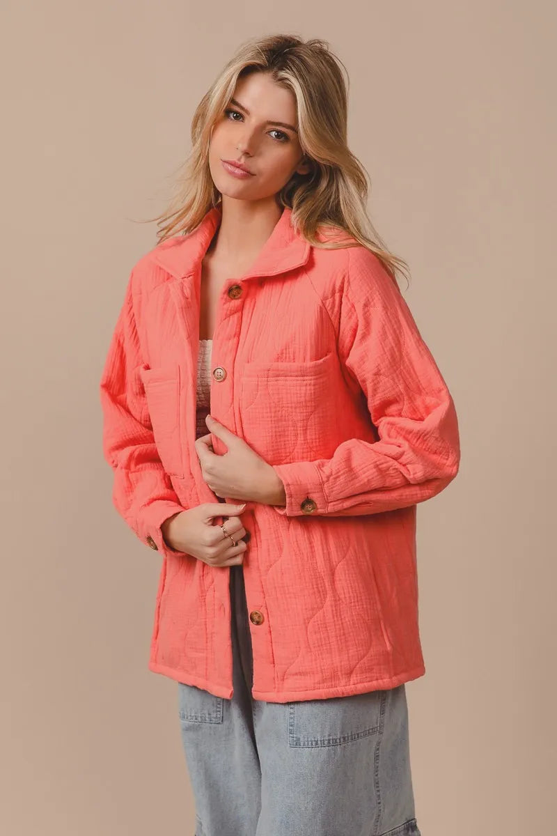 Woman wearing a coral jacket against a beige background 3