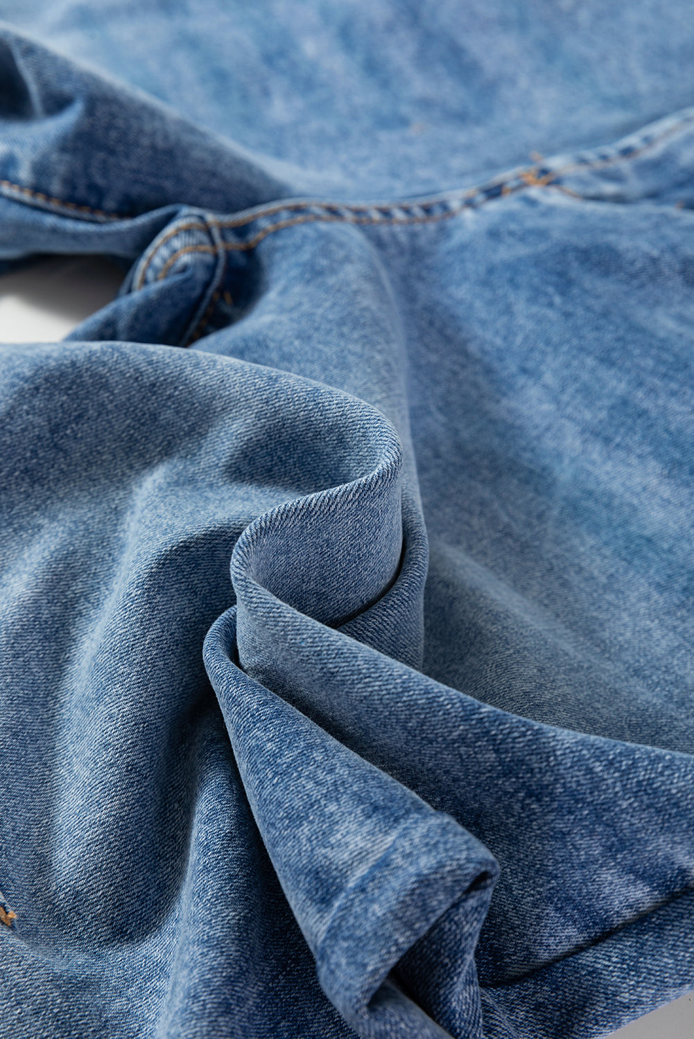 Close-up of blue denim fabric with visible stitching