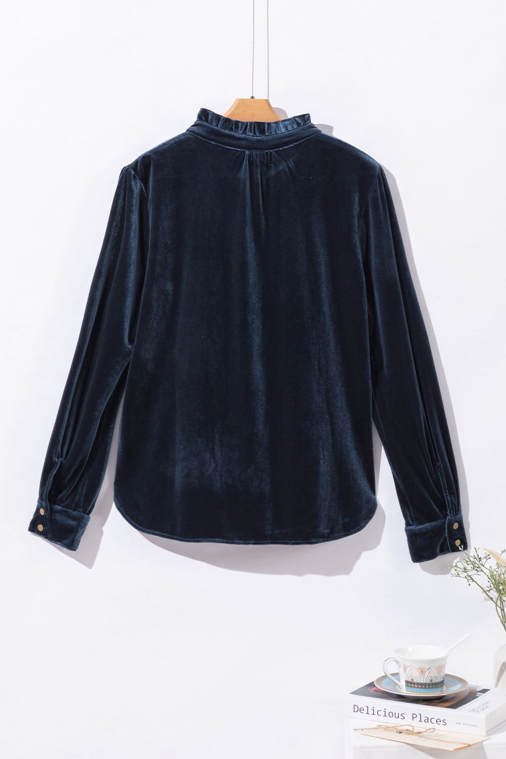 Navy blue velvet shirt on a hanger with a white background