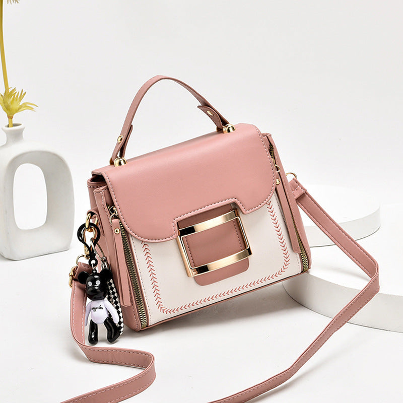 Pink handbag with gold accents on a white background