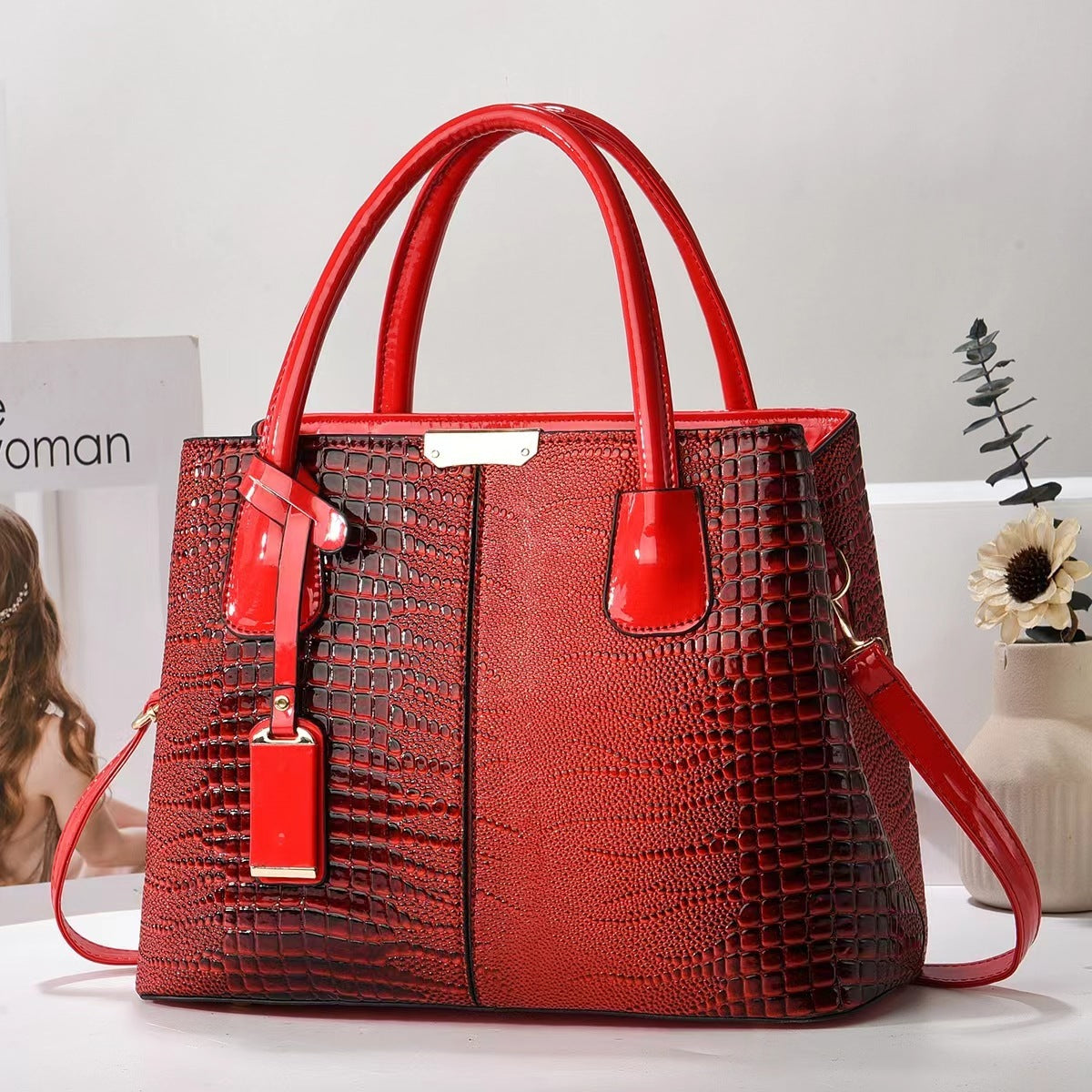 Red textured handbag with matching strap on a light background