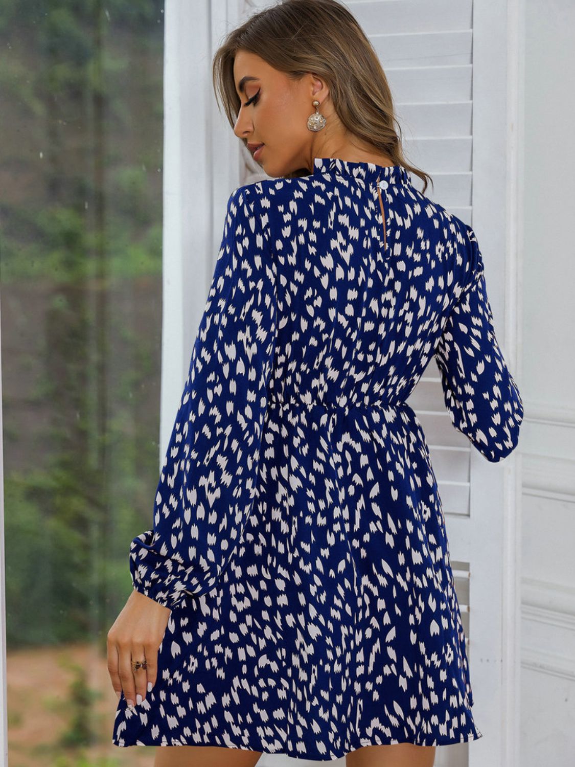 Back view of a Model wearing a Stylish and Comfortable Blue Ladies Printed Frill Neck Long Sleeve Dress