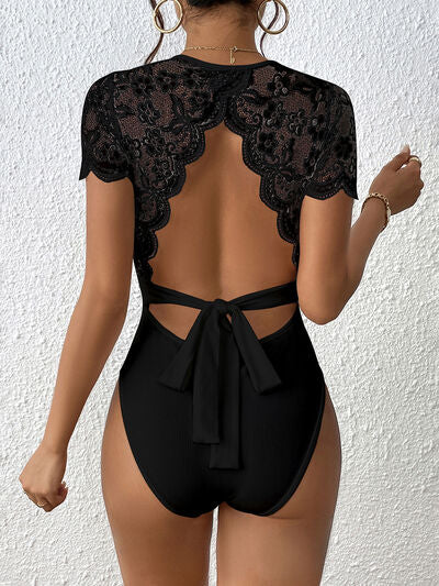 Back view of a Model wearing a Black Flattering Ladies Lace Backless Round Neck Bodysuit