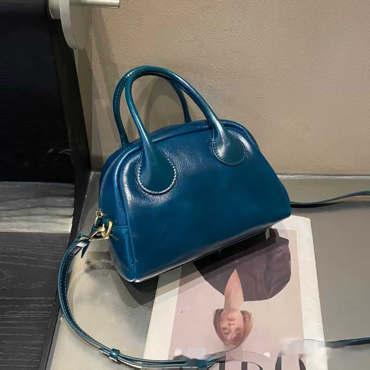 Blue handbag on a magazine with a blurred background