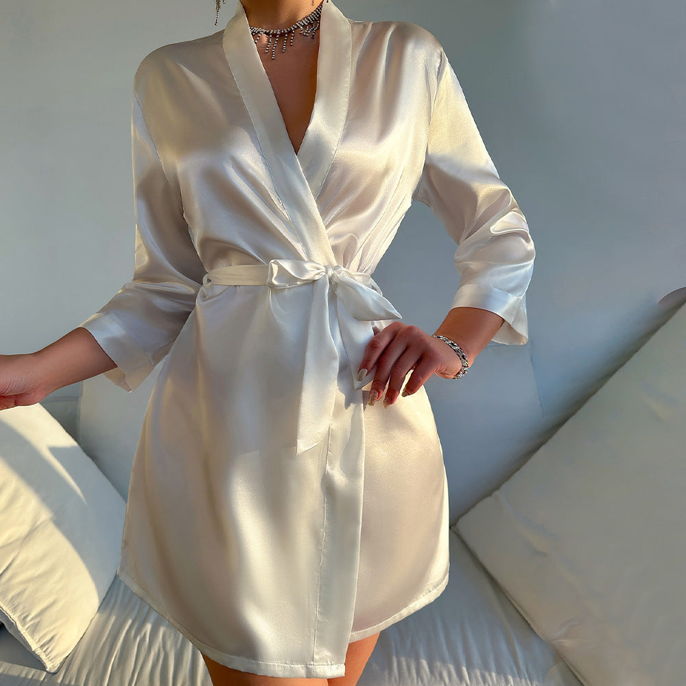 White satin robe worn by a person on a neutral background