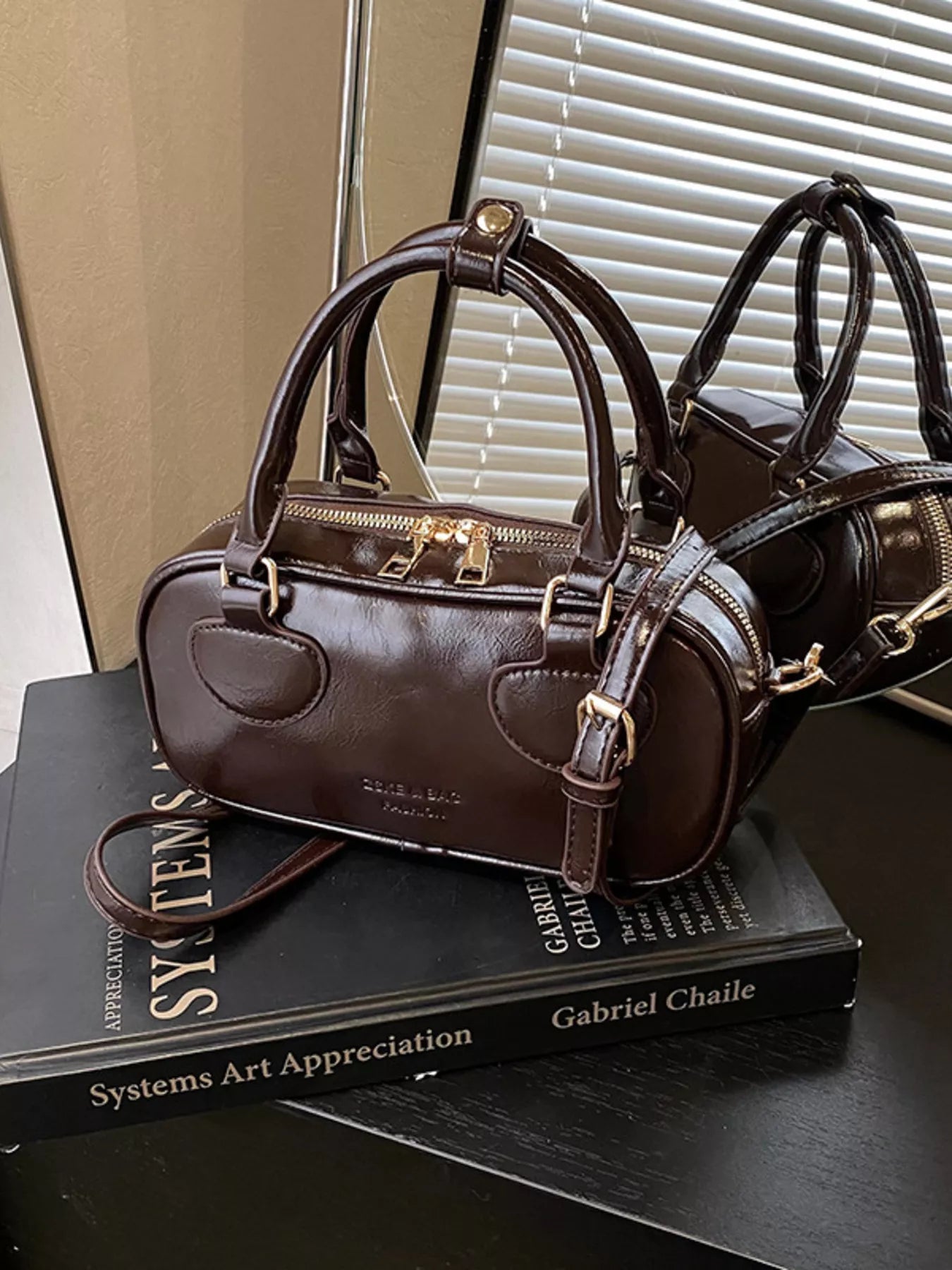 Brown handbag on a black book with a blurred background