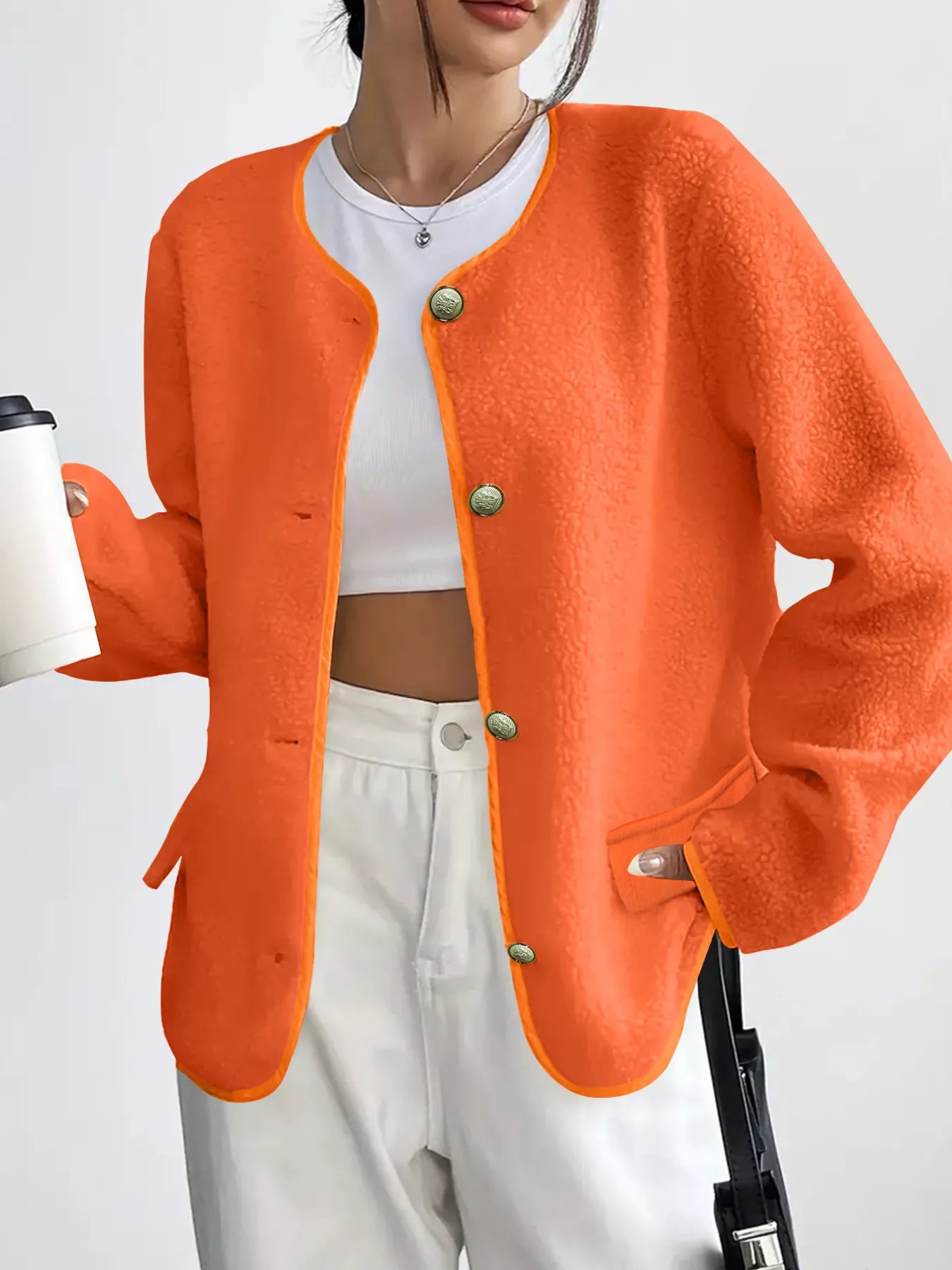 Person wearing an orange cardigan with a white background