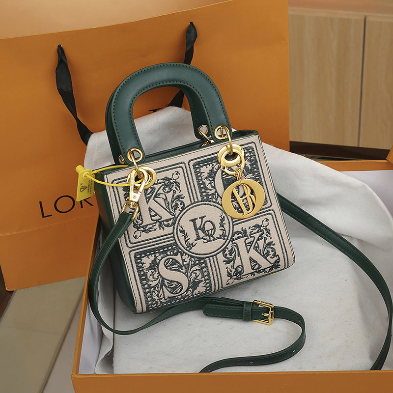 Designer handbag with decorative elements on a branded box
