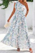 Woman wearing a floral one-shoulder dress against a white wall. Front view