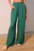 Green wide-leg pants worn by a person on a neutral background