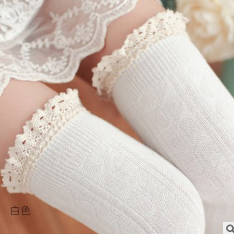 White lace-trimmed socks on a blurred floral background