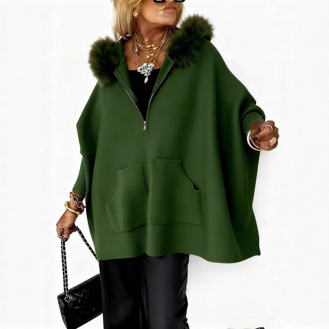 Woman wearing a green cape with fur trim on a white background