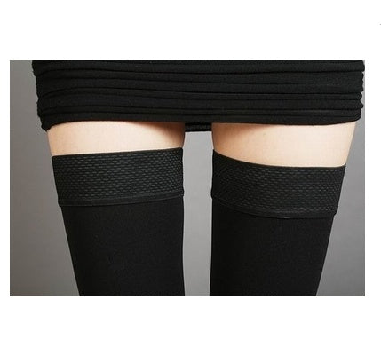 Black knee-high socks with mesh design worn by a person on a plain background