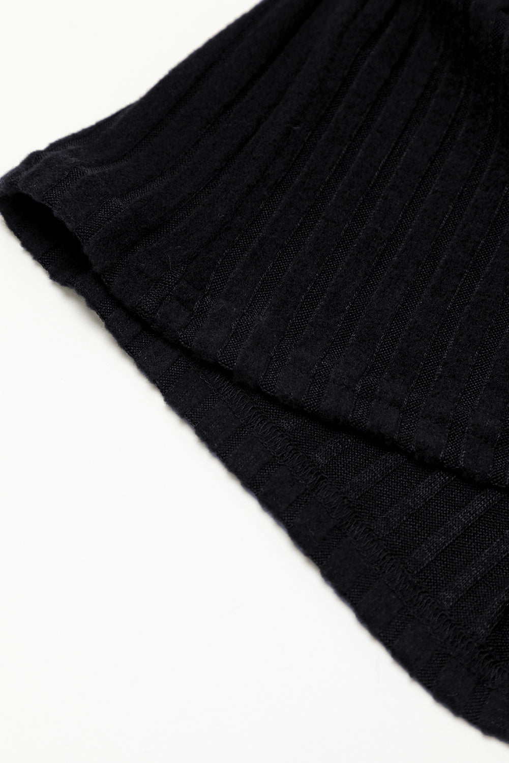 Close-up of a black ribbed knit fabric on a white background
