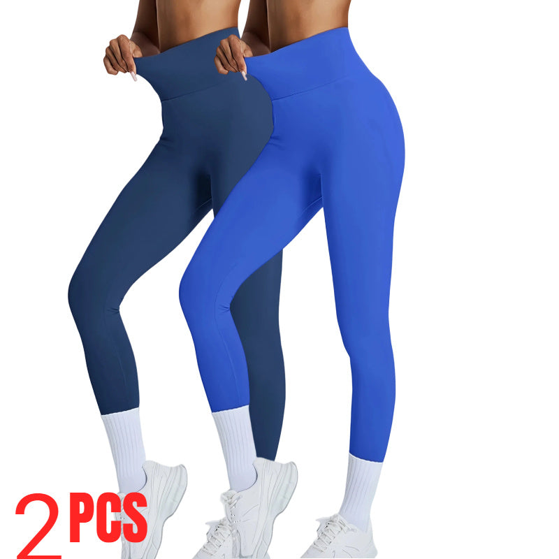 Two pairs of blue leggings held by a person on a white background