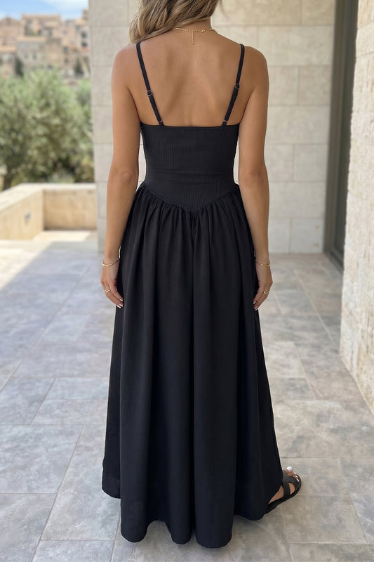 Woman wearing a black dress with thin straps in an outdoor setting. Back view