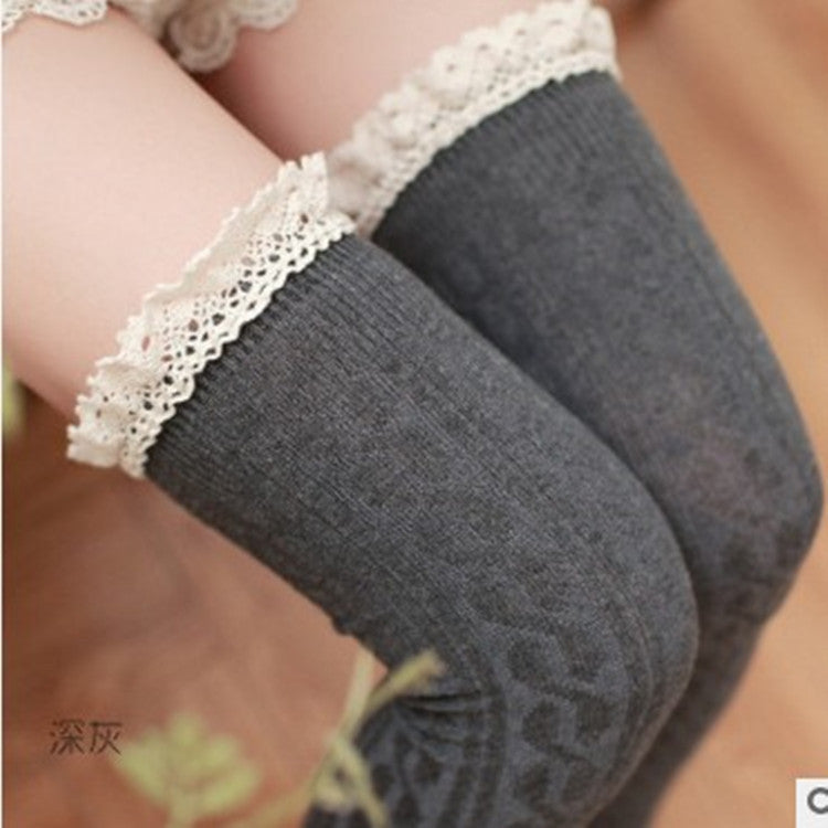 Gray socks with lace trim worn by a person, on a blurred background
