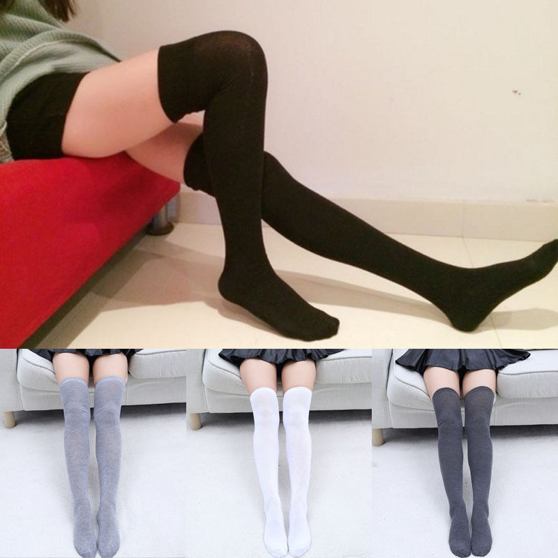 Comparison of black, gray, and white knee-high socks worn by a person sitting on a couch.
