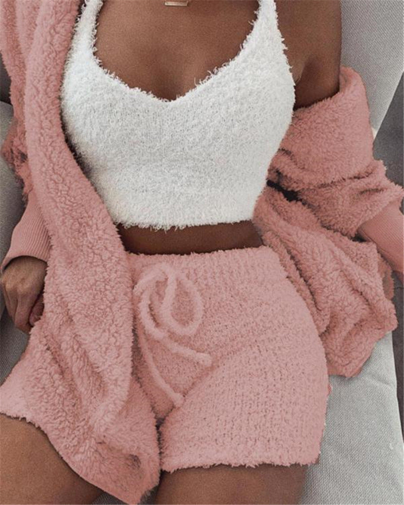 Person wearing a white fuzzy top and pink fuzzy shorts with a matching pink jacket.