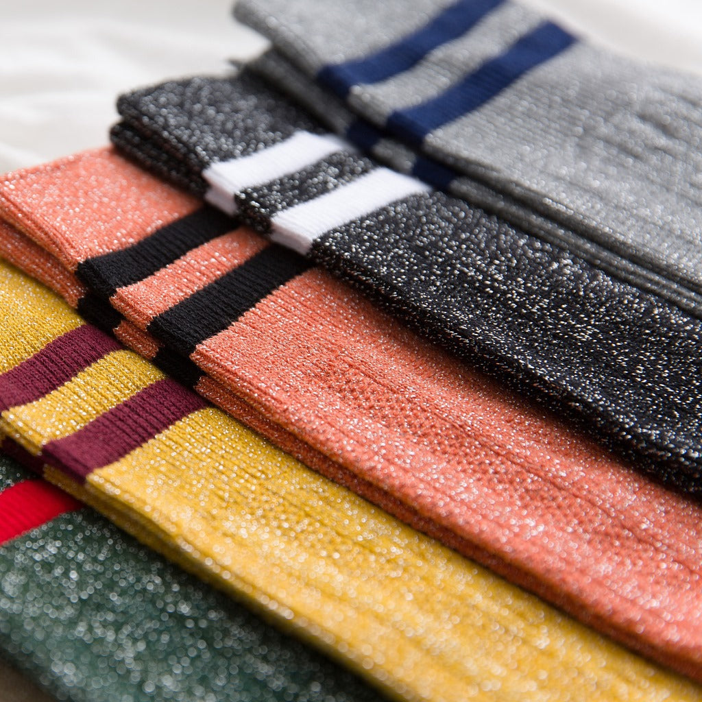 Colorful socks with different patterns and colors arranged on a flat surface.