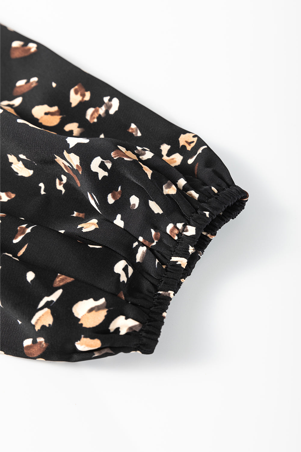 Black shorts with a pattern of small white and brown shapes on a white background