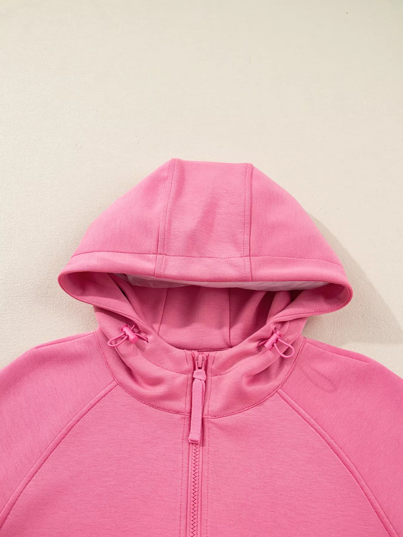 Pink hoodie on a beige background