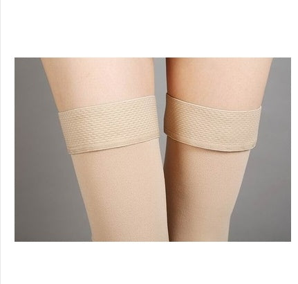 Beige knee-high socks worn by a person on a gray background