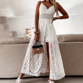 Woman in a white lace dress holding a woven handbag in a modern interior setting.