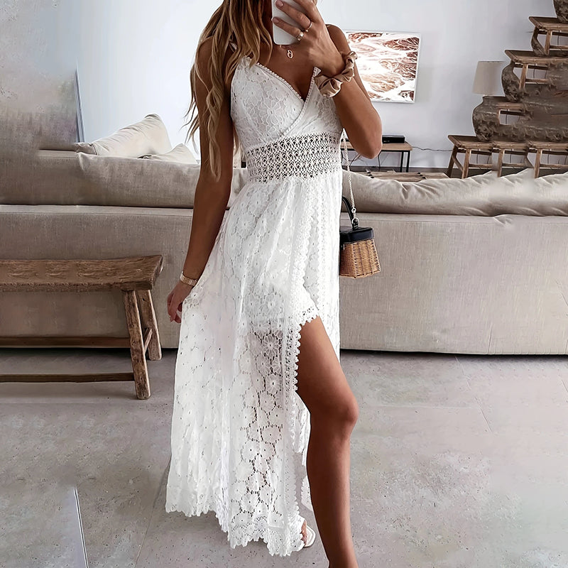 Woman in a white lace dress taking a mirror selfie in a living room.