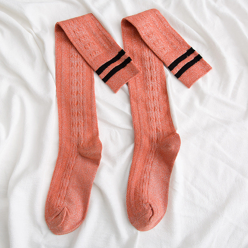 Pair of pink knee-high socks with black stripes on a white background