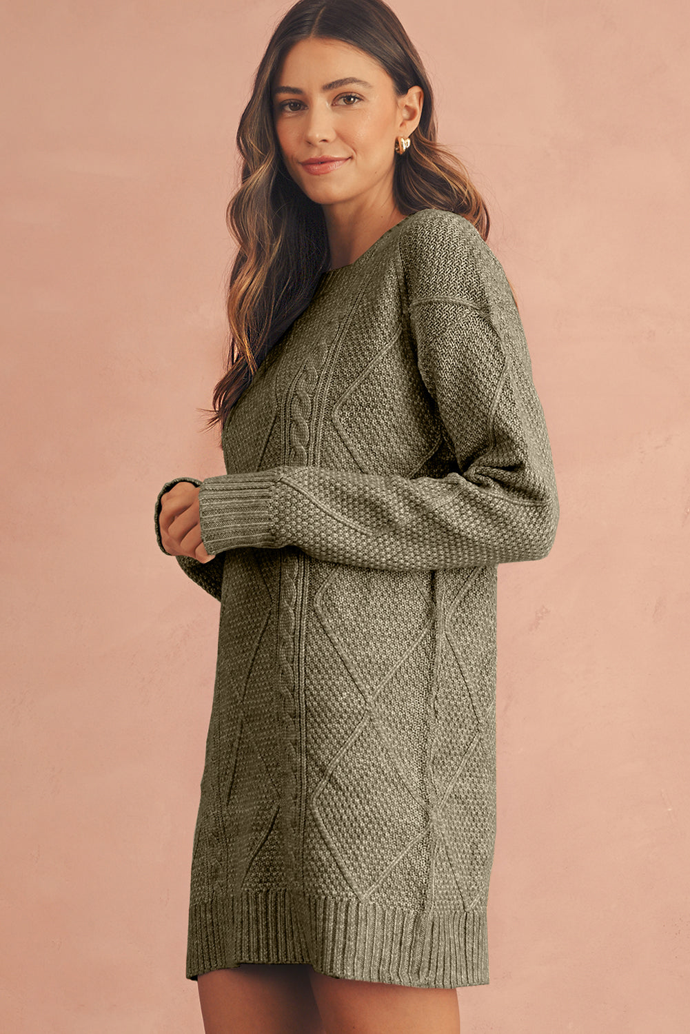 Woman wearing a green cable knit sweater dress side view