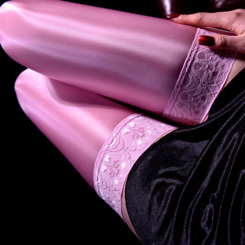 Close-up of pink lace underwear worn by a person against a black background