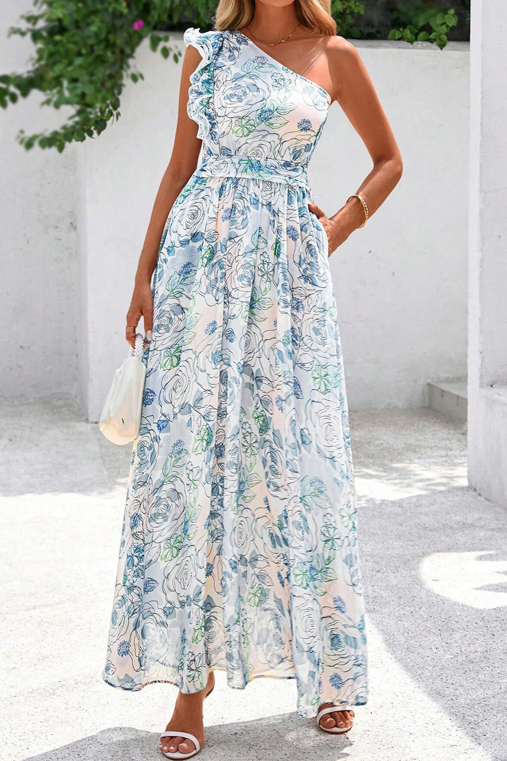 Woman wearing a chich floral one-shoulder dress with a white background