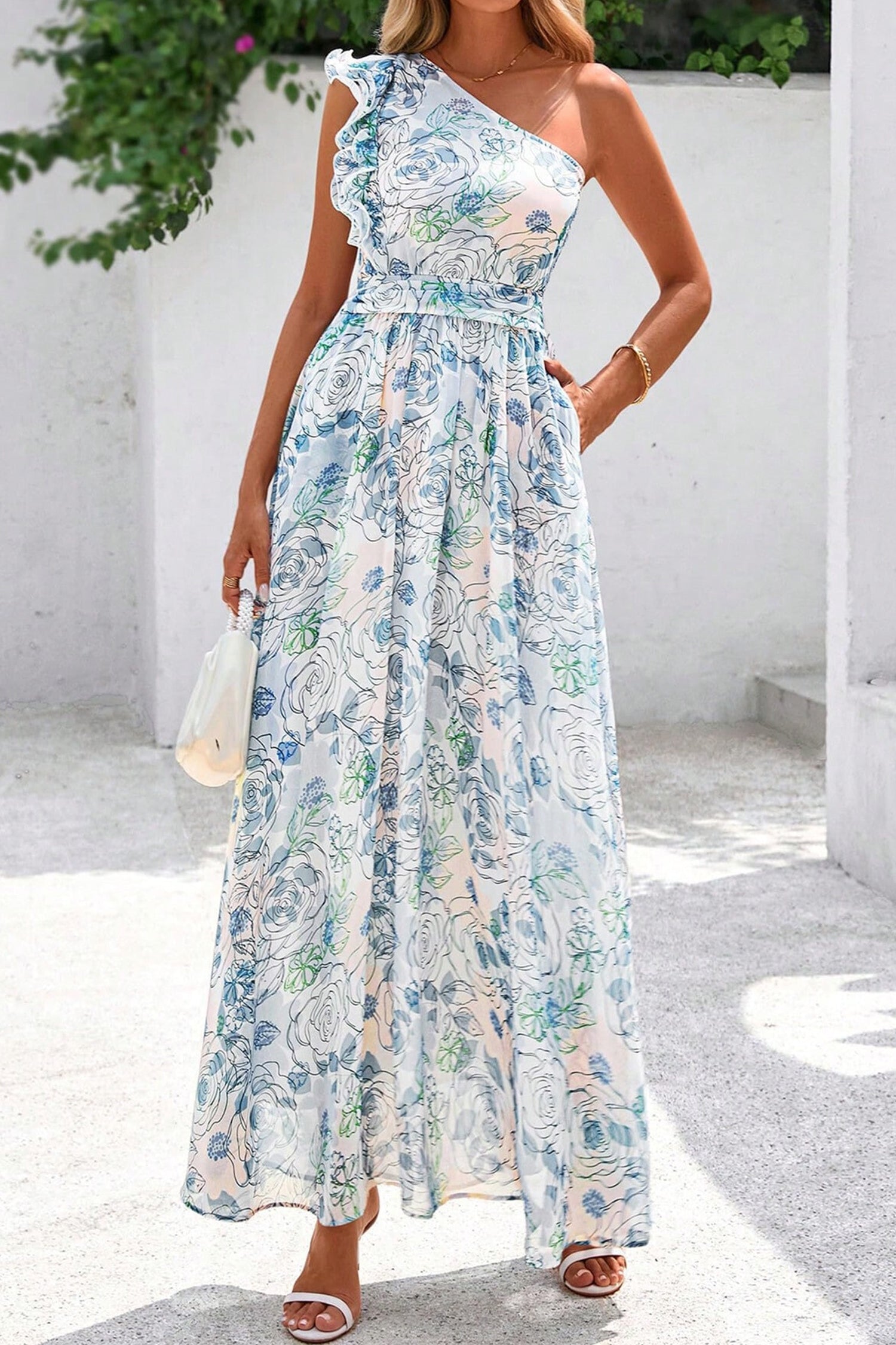Woman wearing a chich floral one-shoulder dress with a white background