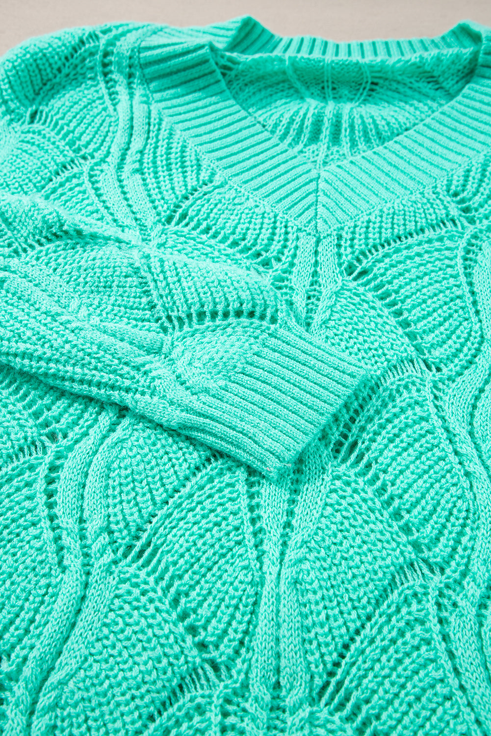 Close-up of a teal knitted sweater with intricate pattern