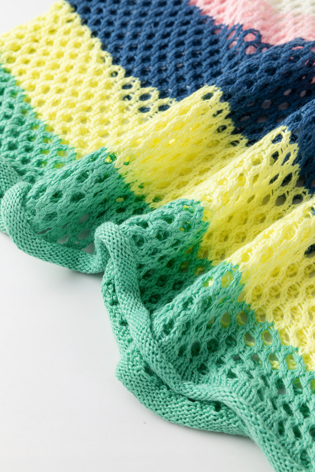 Colorful knitted fabric with green, yellow, and blue patterns on a white background