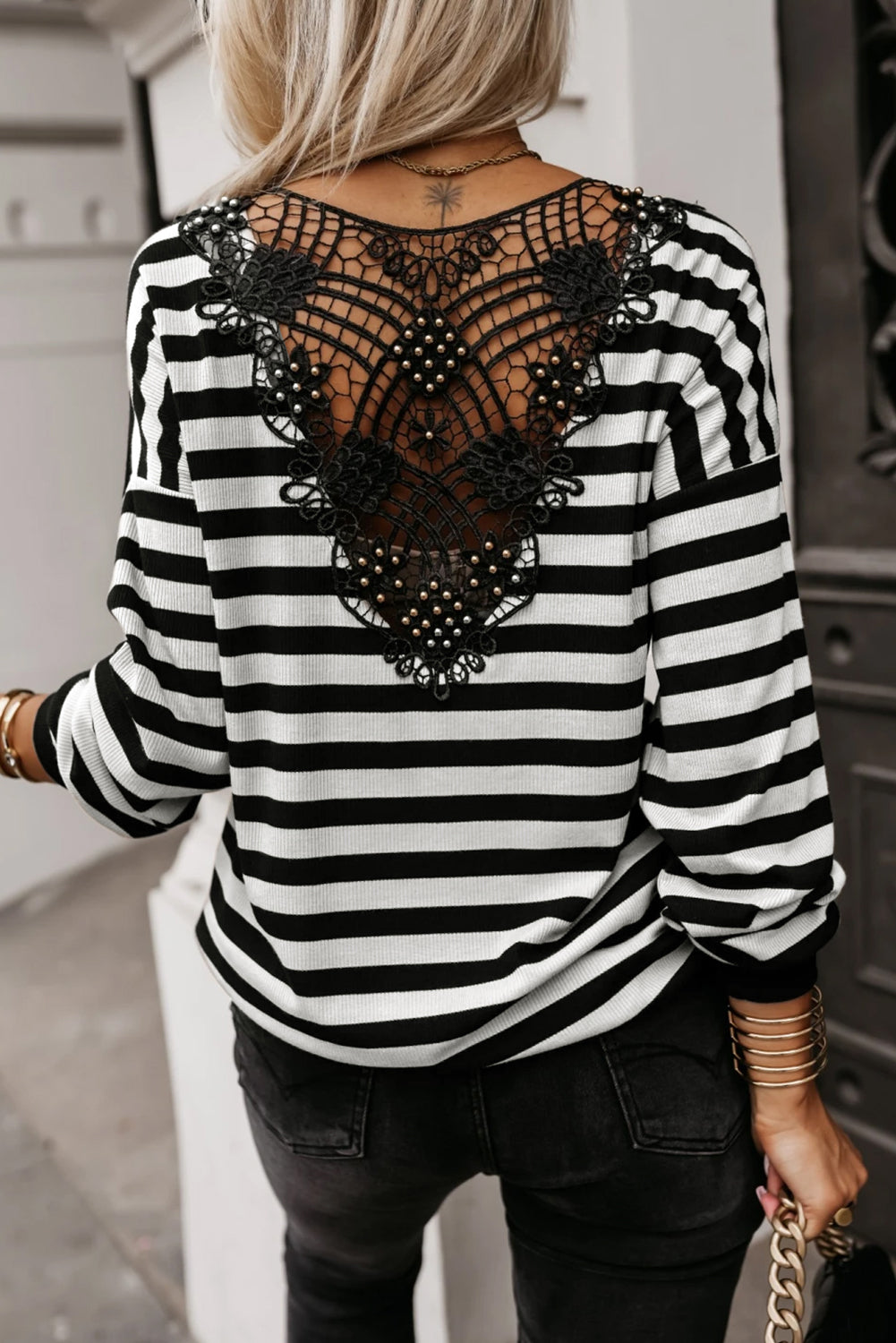 Black and white striped shirt with lace back design worn by a person.