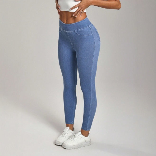 Person wearing blue leggings and white sneakers on a plain background