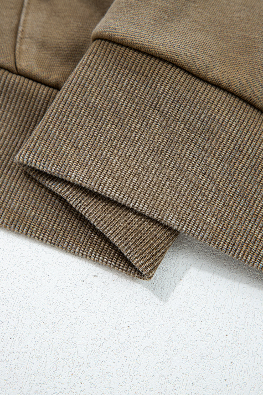 Close-up of brown corduroy fabric on a light gray background