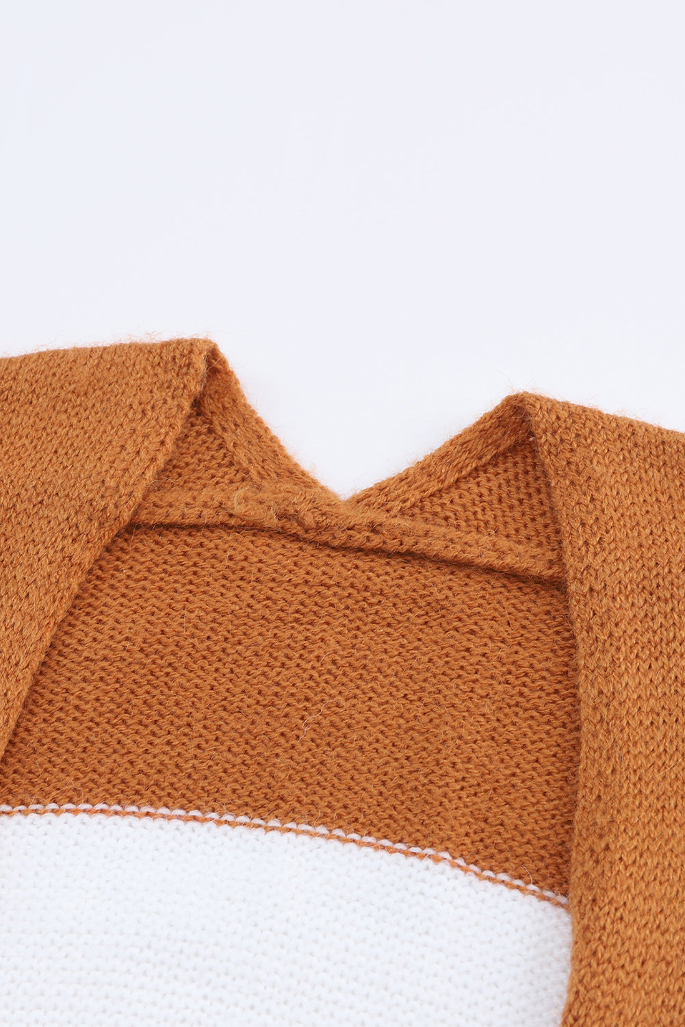 Close-up of a brown and white knitted garment on a light gray background