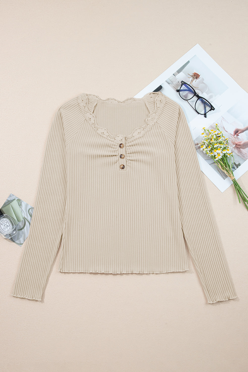 Beige ribbed long-sleeve top on a beige background with a magazine and flowers.