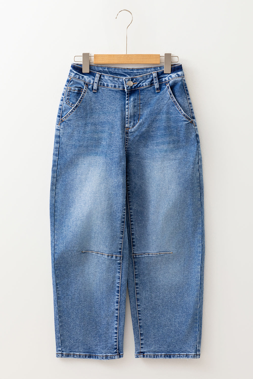 Blue jeans on a hanger against a white background